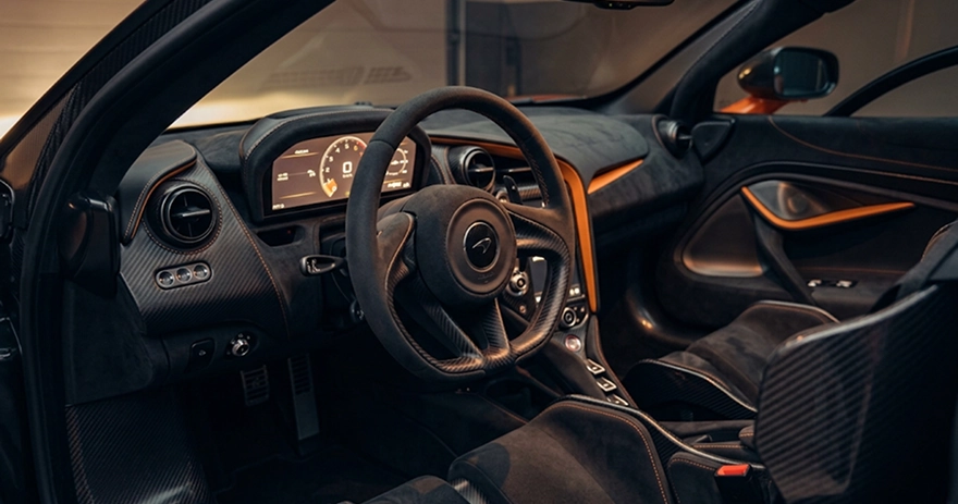 McLaren cockpit with orange accents, a carbon fibre centre console and a digital gauge cluster