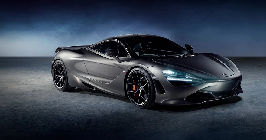 Dark grey McLaren 720S in a moody studio, seen from the front three-quarter