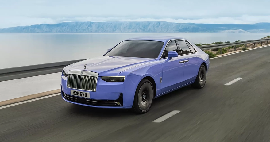 Lilac Rolls-Royce Ghost on a coastal road with the sea and mountains behind it