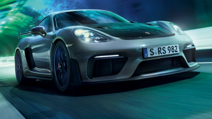Grey Porsche 718 Cayman GT4 RS seen head-on at speed with the background blurring past