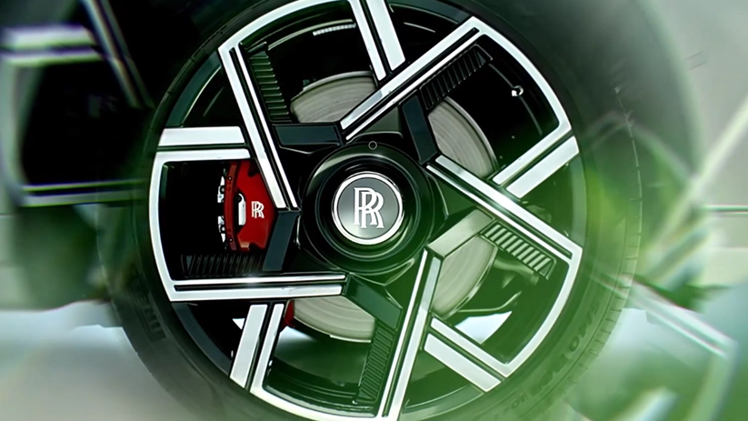 Close-up of a Rolls-Royce 23-inch wheel with a red Black Badge brake caliper behind the spokes