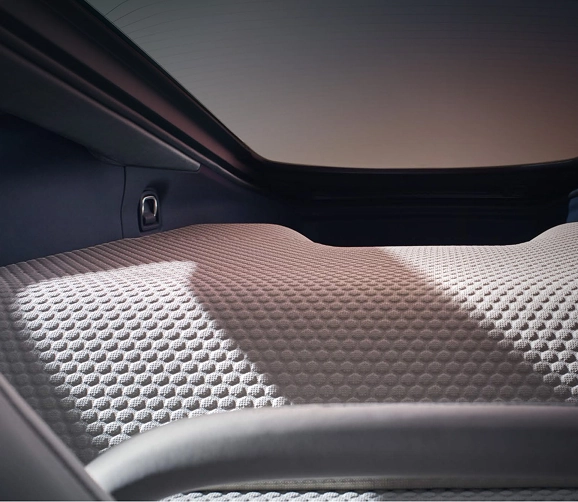 Dimpled quilted leather luggage deck under the glass tailgate of a McLaren GT