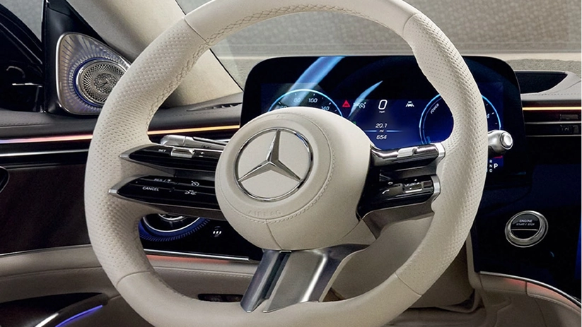 Mercedes-Benz cockpit in cream leather with the digital gauge cluster lit behind the steering wheel