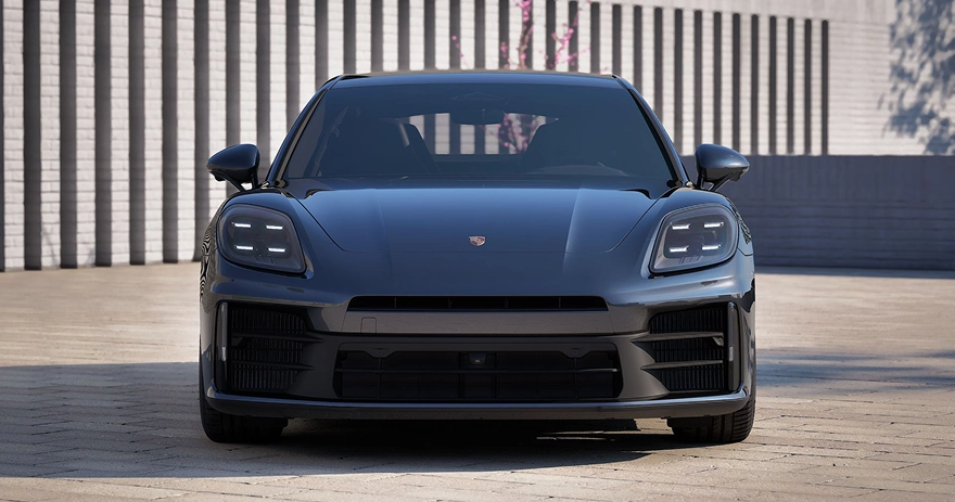 Dark blue Porsche Panamera photographed head-on in front of a white brick colonnade