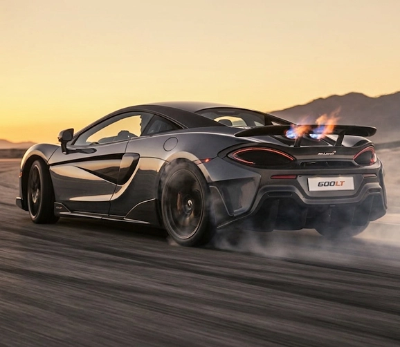 Grey McLaren 600LT accelerating away with flames spitting from its top-exit exhausts