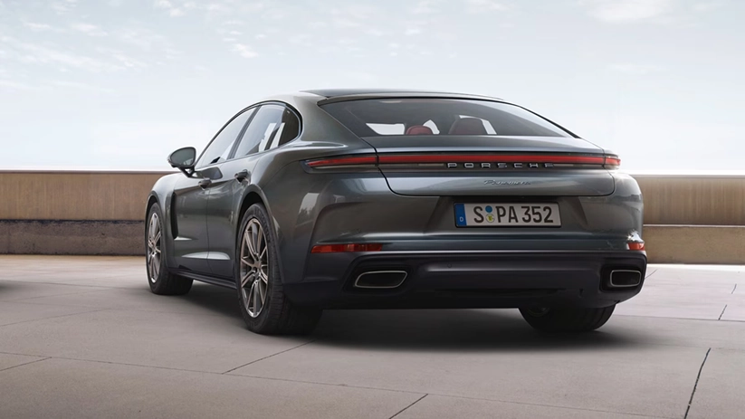 Grey Porsche Panamera seen from the rear, showing its full-width light bar and twin exhaust tips