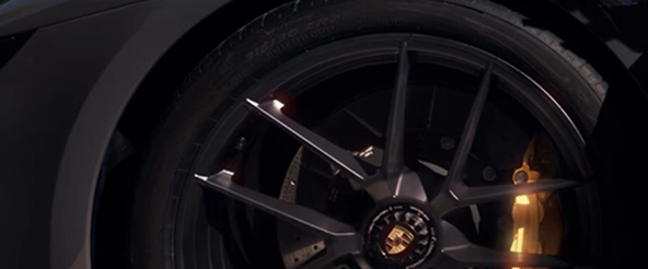 Close-up of a Porsche 911 centre-lock alloy wheel with a yellow ceramic brake caliper