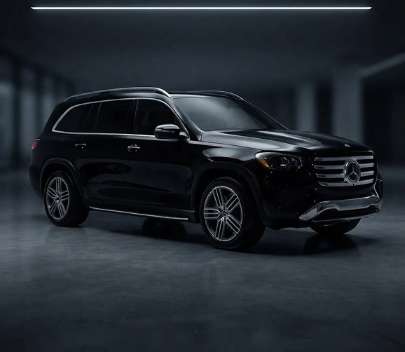 Black Mercedes-Benz GLS seen from the front three-quarter in a dark showroom