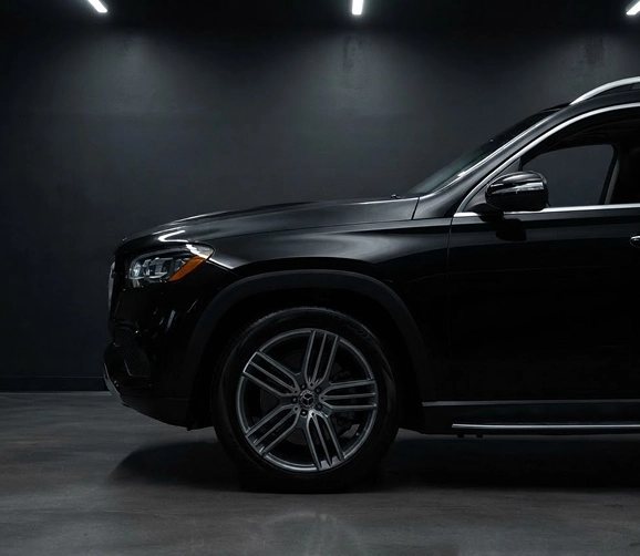 Black Mercedes-Benz GLS front wheel and door in a dark studio