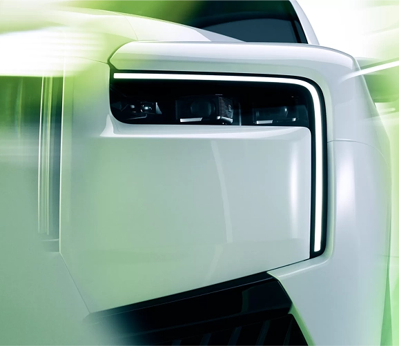 Close-up of the headlight and wing of a white Rolls-Royce Cullinan Black Badge