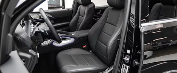 Front seats and steering wheel of a Mercedes-Benz GLS seen through the open driver's door