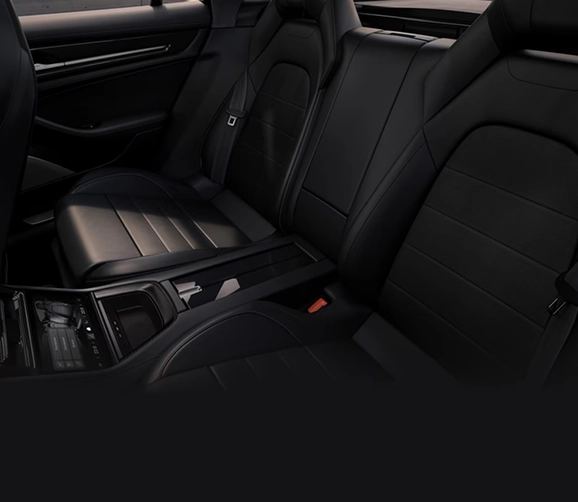 Rear cabin of a Porsche Panamera with black leather individual seats and a rear centre console