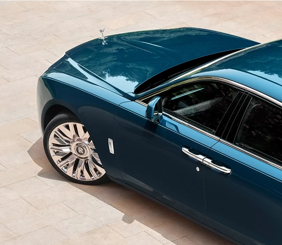 Teal Rolls-Royce Ghost seen from above, showing its roofline, coach door handle and polished wheel