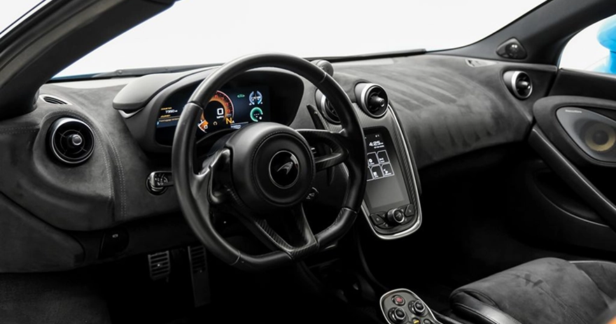 Alcantara-trimmed McLaren 600LT cockpit with a digital gauge cluster and a slim portrait screen beside the wheel