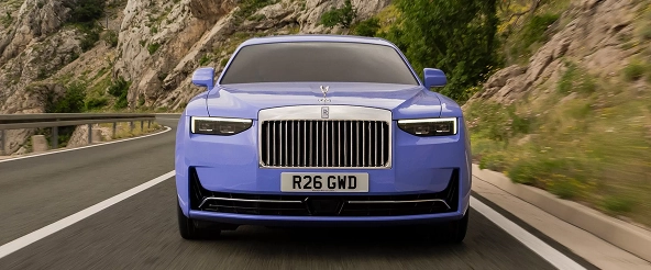 Head-on view of a lilac Rolls-Royce Ghost at speed on a mountain road