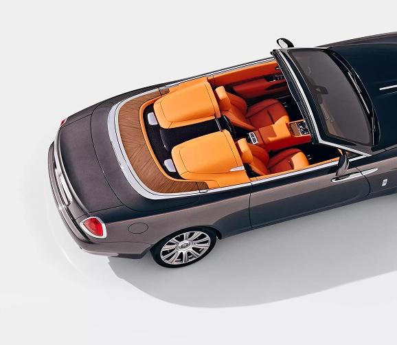 Overhead view of a Rolls-Royce Dawn's four-seat cabin in orange leather with a wood deck