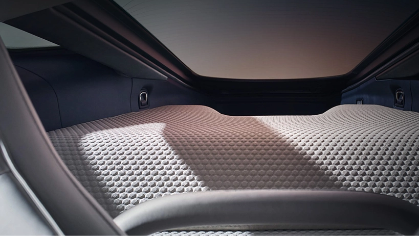 Dimpled quilted leather luggage deck under the glass tailgate of a McLaren GT