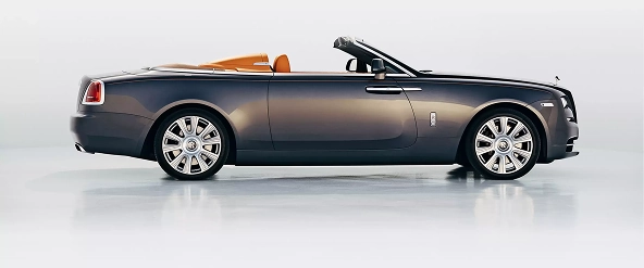 Silver Rolls-Royce Dawn convertible in profile in a white studio with the roof down