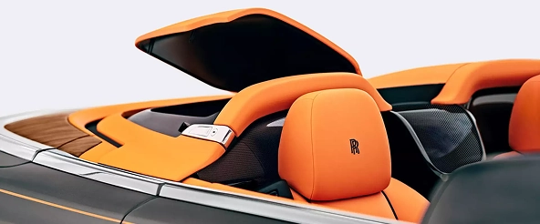 Rolls-Royce Dawn's orange front seats and carbon trim seen from above with the roof stowed