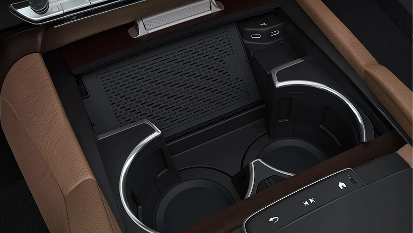 Wireless charging tray in a Mercedes-Benz centre console beside brown leather trim
