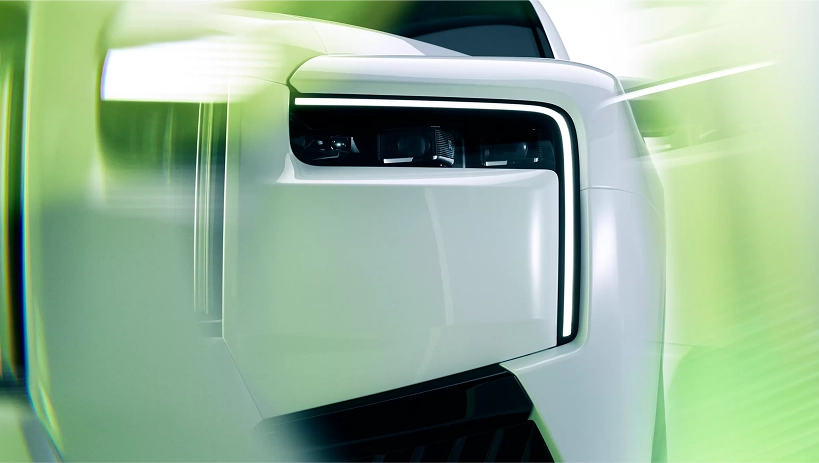 Close-up of a white Rolls-Royce Cullinan Black Badge's headlight and wing in motion