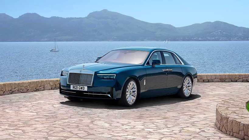 Teal Rolls-Royce Ghost parked on a stone terrace overlooking a bay
