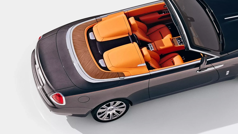 Overhead view of a Rolls-Royce Dawn's orange four-seat cabin with the roof stowed