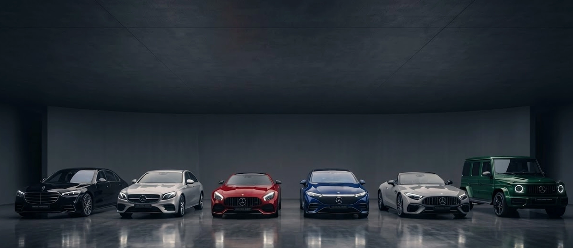 A black S-Class, a silver sedan, a red AMG GT, a blue coupe, a silver AMG and a green G-Class lined up in a dark studio