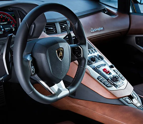 Lamborghini Aventador cockpit with its steering wheel and red flip-cover starter button