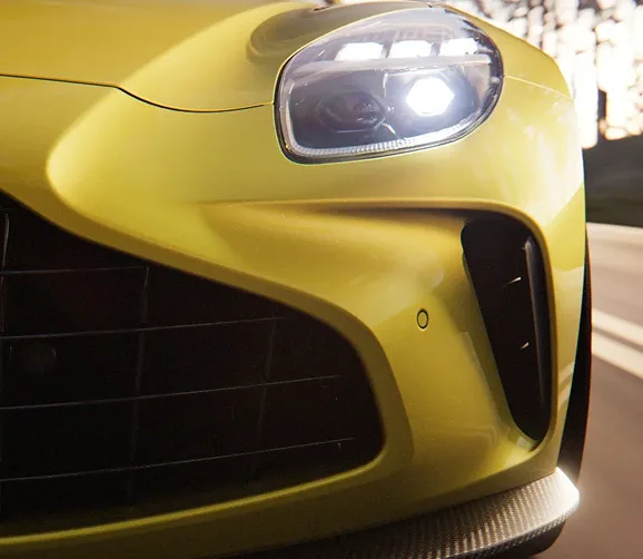Close-up of a yellow Aston Martin Vantage headlight and front wing