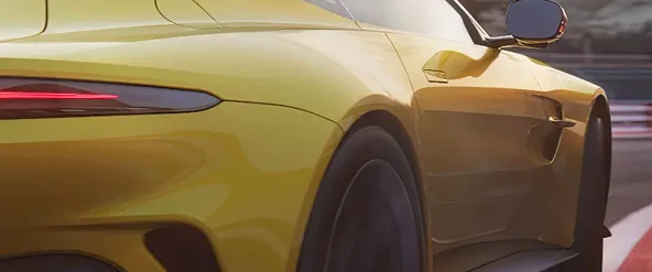 Rear quarter of a yellow Aston Martin Vantage on track
