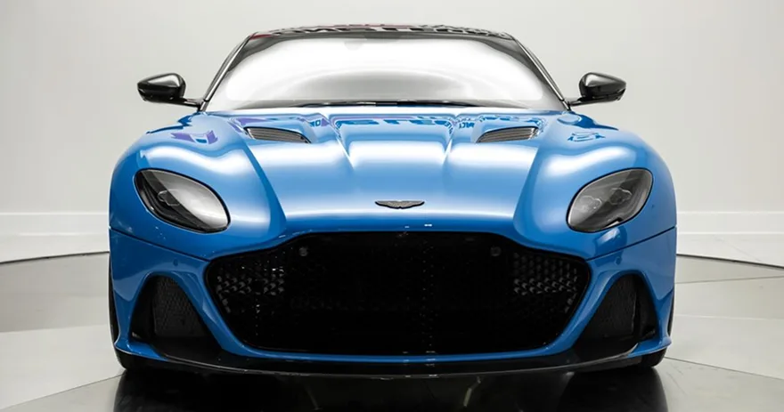 Blue Aston Martin DBS Superleggera photographed head-on in a studio