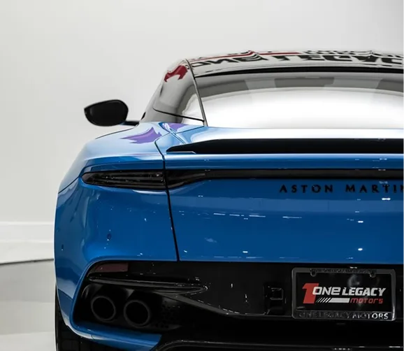 Rear view of a blue Aston Martin DBS Superleggera showing its badge and quad exhausts