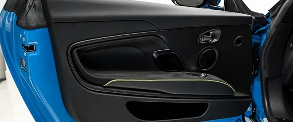 Open door of a blue Aston Martin DBS Superleggera showing the sill and trim