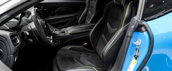 Interior of a blue Aston Martin DBS Superleggera with lime green contrast stitching