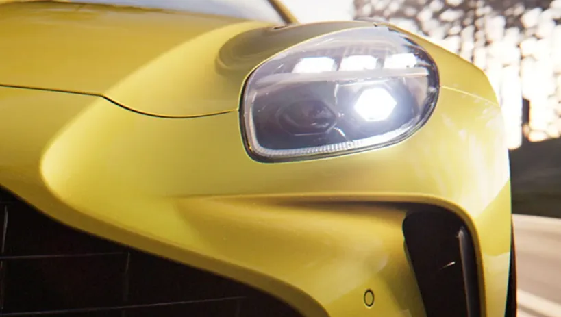 Close-up of a yellow Aston Martin Vantage headlight and front wing