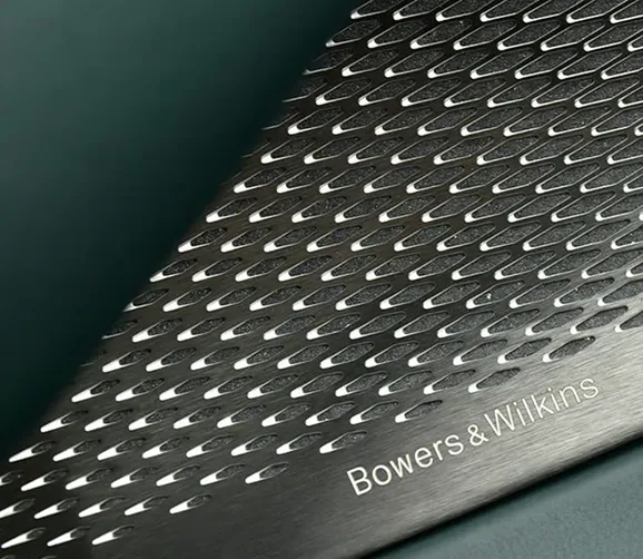Close-up of a perforated speaker grille in an Aston Martin cabin