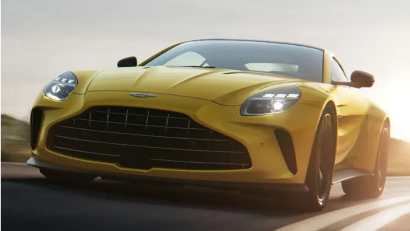 Front three-quarter view of a yellow Aston Martin Vantage at speed