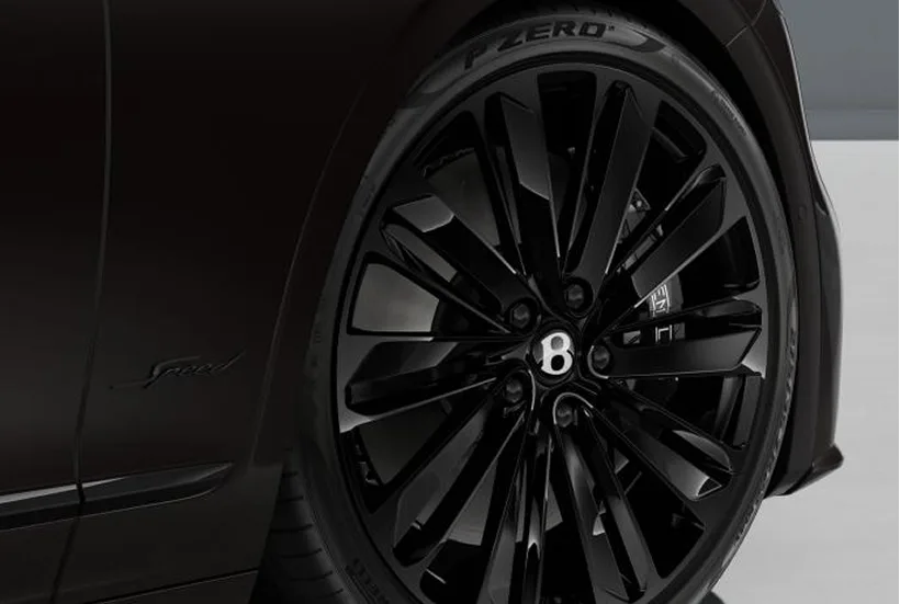 Rear detail of a dark Bentley showing its wheel and body surfacing