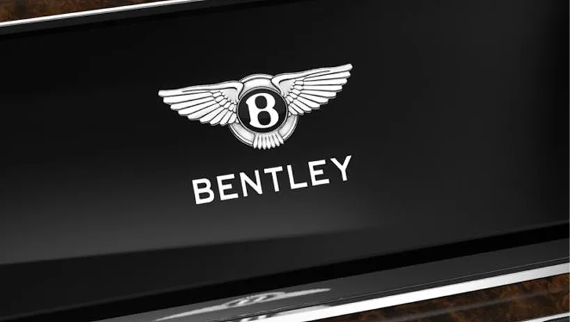 Bentley centre console with knurled controls and the winged B on wood veneer