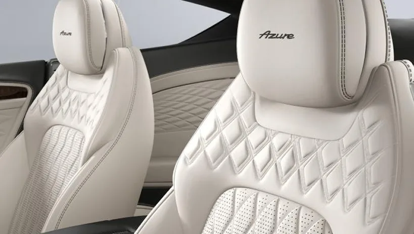 Cream quilted Bentley front seats beneath a panoramic roof