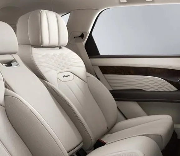 Rear cabin of a Bentley Bentayga EWB with cream quilted seats and a panoramic roof