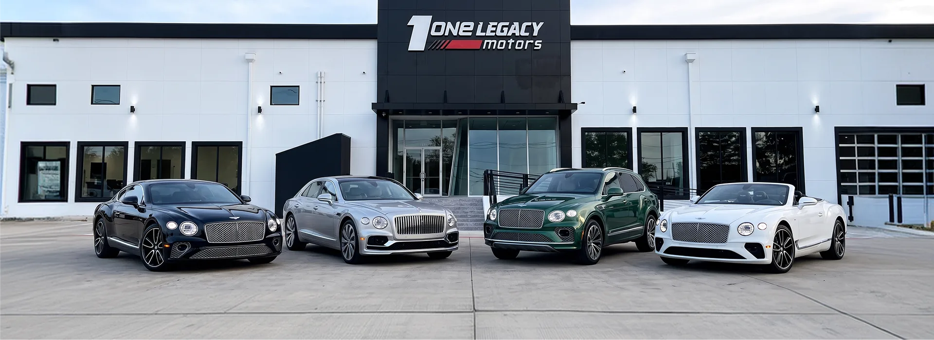 Dark blue, silver, green and white Bentleys parked side by side outside the One Legacy Motors showroom in Carrollton, Texas