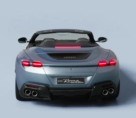 Rear view of a silver-blue Ferrari Roma Spider showing its quad exhaust tips and taillights