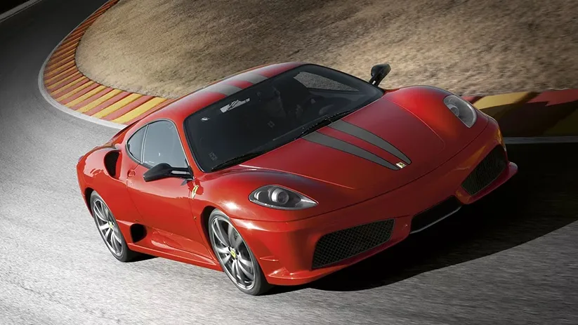 Red Ferrari F430 Scuderia cornering hard through a banked curve