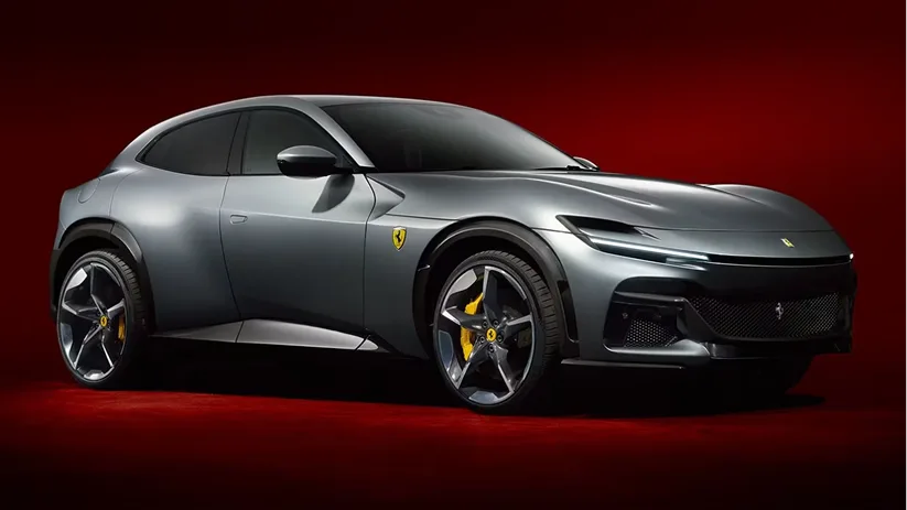 Grey Ferrari Purosangue in profile against a deep red studio backdrop