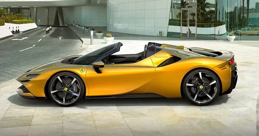 Yellow Ferrari SF90 Spider with the roof down parked beside a modern glass building