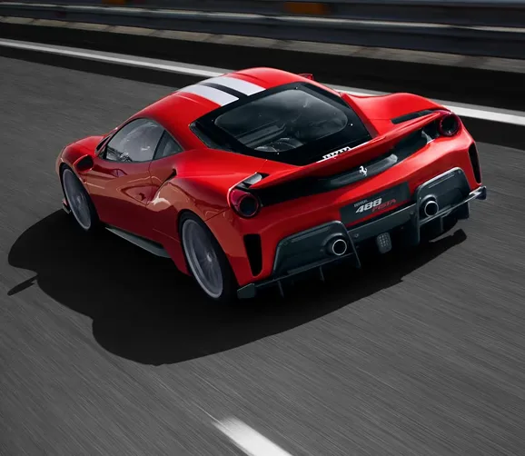 Rear three-quarter view of a striped red Ferrari 488 Pista accelerating down a race track