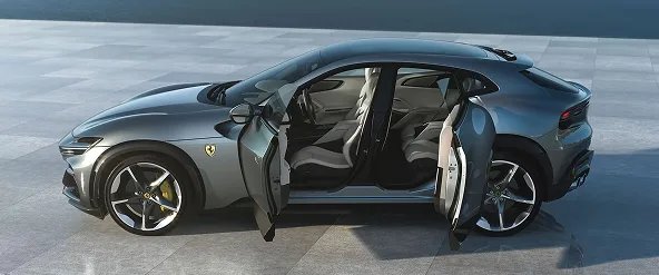 Grey Ferrari Purosangue with all four rear-hinged doors open on a seaside terrace
