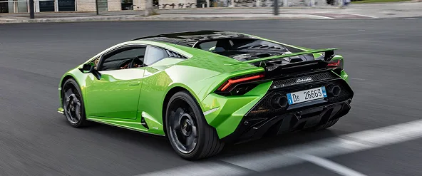 Green Lamborghini Huracan Spyder driving through a city street